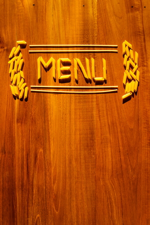 Menu lettering from penne and macaroni pasta on wooden tableの写真素材
