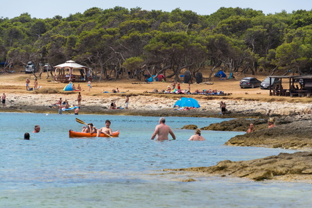 PREMANTURA, CROATIA - JULY 28: Tourists sailing on kayak on Kamenjak peninsula by the Adriatic Sea on July 28, 2016 in Premantura, Croatia.のeditorial素材
