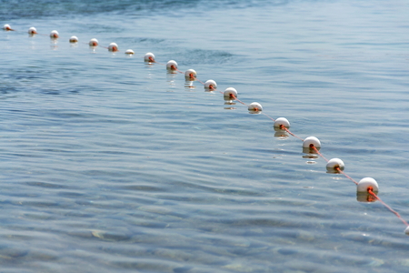 Buoys on fish net floating on surface of water の写真素材