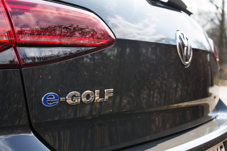 DRESDEN, GERMANY - APRIL 2 2018: Volkswagen e-Golf plug-in hybrid electric car stands by charging station on April 2, 2018 in Dresden, Germany.のeditorial素材