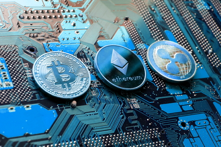 Bitcoin, Ethereum, Ripple coins on computer motherboard, cryptocurrency investing conceptの写真素材