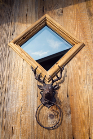 Antique metal handle knocker deer head on wooden doorの写真素材