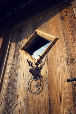 Antique metal handle knocker deer head on wooden doorの写真素材
