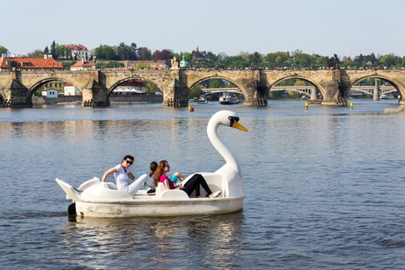 PRAGUE, CZECH REPUBLIC - APRIL 21 2018: Tourist sailing on pedal boats on Vltava river near Charles bridge on April 21, 2018 in Prague, Czech Republic.のeditorial素材