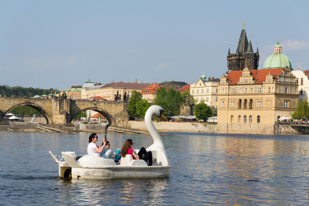 PRAGUE, CZECH REPUBLIC - APRIL 21 2018: Tourist sailing on pedal boats on Vltava river near Charles bridge on April 21, 2018 in Prague, Czech Republic.のeditorial素材