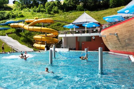 SAALBACH, AUSTRIA - JUNE 20 2018: People swimming in beautiful pool near Schattberg X-press cable car station in Saalbach on June 20, 2018 in Saalbach, Austria.のeditorial素材