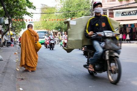 HO CHI MINH CITY - FEBRUARY 5: Monk walks barefoot on busy street on February 5, 2012 in Ho Chi Minh City, Vietnam.のeditorial素材