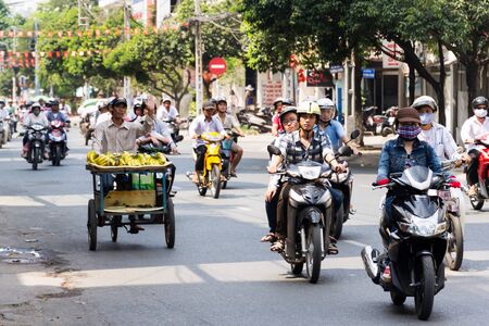 HO CHI MINH CITY - FEBRUARY 5: Vendor man selling bananas on busy street on February 5, 2012 in Ho Chi Minh City, Vietnam.のeditorial素材