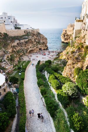 POLIGNANO A MARE, ITALY - JULY 6 2018: People on lovely beach Lama Monachile, Adriatic Sea, Apulia, Bari province on July 6, 2018 in Polignano a Mare, Italy.のeditorial素材