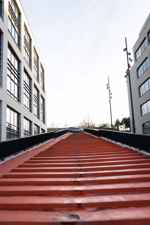 Red stairs leading to sky between modern office buildings, coworkin and working space conceptの写真素材