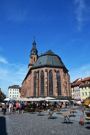 HEIDELBERG, GERMANY- JULY 17: Tourists walk in front of the Church of the Holy Spirit on Marktplatz on July 17, 2014 in Heidelberg, Germany.のeditorial素材