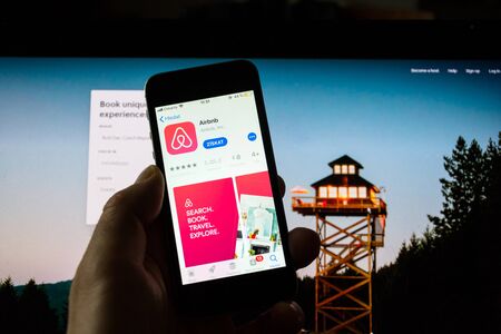 PRAGUE, CZECH REPUBLIC - NOVEMBER 21 2018: Airbnb company logo on mobile app phone screen with internet homepage in background on November 21, 2018 in Prague, Czech republic.のeditorial素材