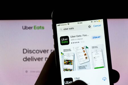 PRAGUE, CZECH REPUBLIC - NOVEMBER 21 2018: Uber Eats Food delivery company logo on mobile app phone screen with internet homepage in background on November 21, 2018 in Prague, Czech republic.のeditorial素材