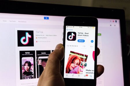 PRAGUE, CZECH REPUBLIC - NOVEMBER 22 2018: TikTok mobile video-sharing app company logo on phone screen with internet homepage in background on November 22, 2018 in Prague, Czech republic.のeditorial素材