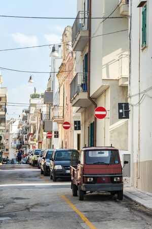 POLIGNANO A MARE, ITALY - JULY 6 2018: People walk along parked cars on street with many no entry traffic signs on July 6, 2018 in Polignano a Mare, Italy.のeditorial素材