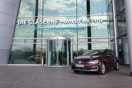 DRESDEN, GERMANY - APRIL 2 2018: Plug-in hybrid Volkswagen e-Golf electric car stands in front of the Glaserne Manufaktur - Transparent Factory on April 2, 2018 in Dresden, Germany.のeditorial素材