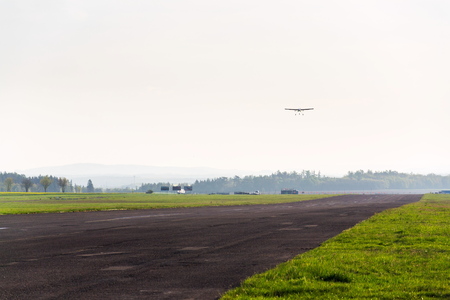 Unmanned aerial vehicle surveillance drone with light and camera landing on airport runway, ground, airfield, sunny summer morning, drone delivery concept, copy space on clear skyの写真素材