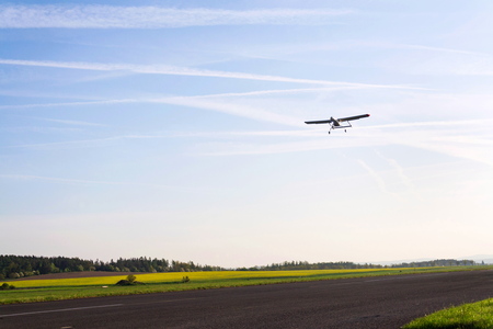 Unmanned aerial vehicle surveillance drone with light and camera landing on airport runway, ground,...