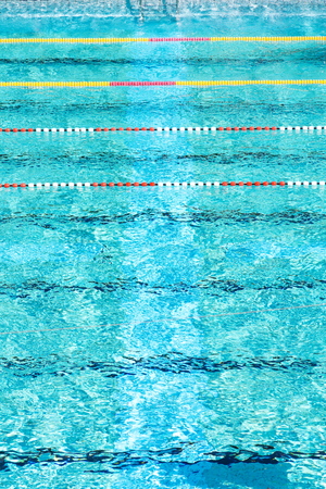 Red and white swimming lanes in beautiful blue water, empty outdoor swimming pool, summer sunny day, copy space, aerial viewの写真素材