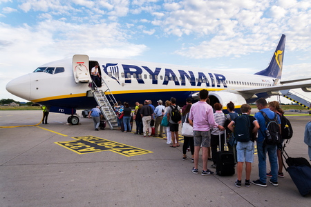 MEMMINGEN, GERMANY - JULY 6 2019: People boarding Ryanair Irish low-cost airline plane Boeing 737 with cloudy sky background on July 6, 2019 in Memmingen, Germany.のeditorial素材