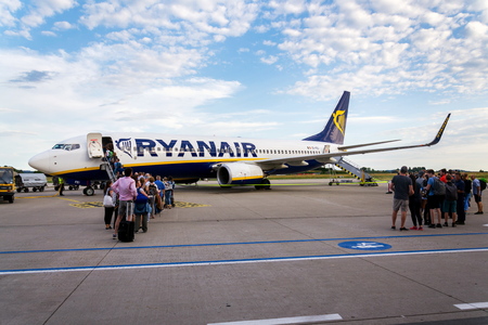 MEMMINGEN, GERMANY - JULY 6 2019: People boarding Ryanair Irish low-cost airline plane Boeing 737 with cloudy sky background on July 6, 2019 in Memmingen, Germany.のeditorial素材