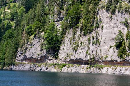 Unrecognizable people climbing on Laserer alpin via ferrata over Vorderer Gosausee lake near Gosau, Austria, sunny summer dayの写真素材