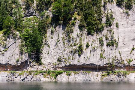 Unrecognizable people climbing on Laserer alpin via ferrata over Vorderer Gosausee lake near Gosau, Austria, sunny summer dayの写真素材