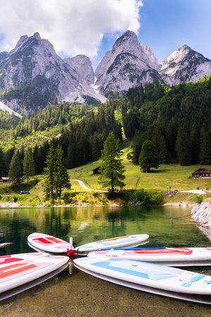 GOSAU, AUSTRIA - JULY 4 2019: Paddle surf lying on surface of Vorderer Gosausee lake near bank on July 4, 2019 in Gosau, Austria.のeditorial素材