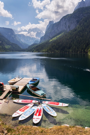 GOSAU, AUSTRIA - JULY 4 2019: Paddle surf lying on surface of Vorderer Gosausee lake near bank on July 4, 2019 in Gosau, Austria.のeditorial素材