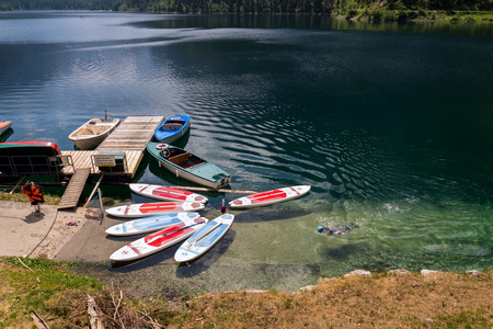 GOSAU, AUSTRIA - JULY 4 2019: Paddle surf lying on surface of Vorderer Gosausee lake near bank on July 4, 2019 in Gosau, Austria.のeditorial素材