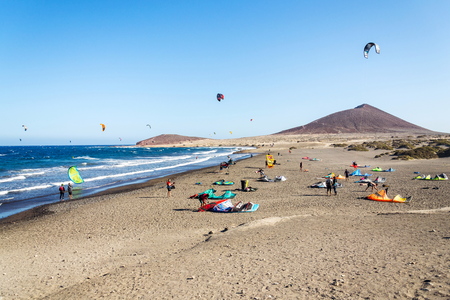 EL MEDANO, SPAIN - JULY 7 2019: People surfing, kiting and windsurfing on Playa de Leocadio Machado beach in Granadilla de Abona municipality on July 7, 2019 in El Medano, Spain.のeditorial素材