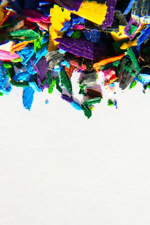 Bright colorful wooden pencil and crayon shavings on white paper background, copy space, creativity and art school conceptの写真素材