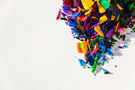 Bright colorful wooden pencil and crayon shavings on white paper background, copy space, creativity and art school conceptの写真素材