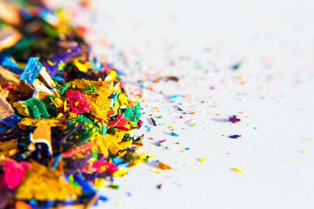 Bright colorful wooden pencil and crayon shavings on white paper background, copy space, creativity and art school conceptの写真素材