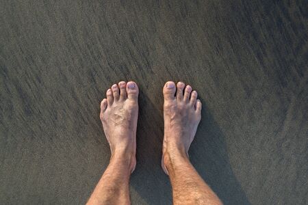 Human barefoot feet in wet sand on sea shore, active healthy living and personal growth concept, copy spaceの写真素材