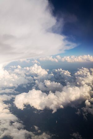 Beautiful white fluffy clouds viewed from airplane, blue sky background, aerial view, copy space, travel conceptの写真素材