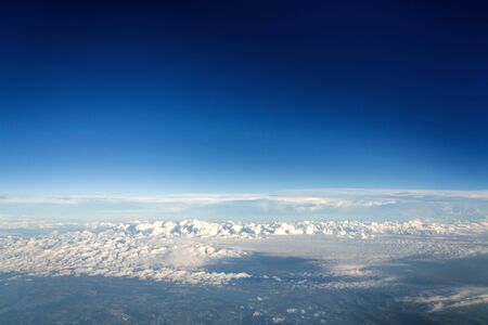 Beautiful white fluffy clouds viewed from airplane, blue sky background, aerial view, copy space, travel conceptの写真素材