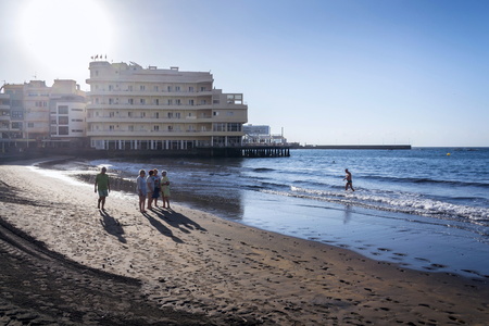 EL MEDANO, SPAIN - JULY 9 2019: Senior local women walking on Playa El Medano beach during sunrisee on July 9, 2019 in El Medano, Spain.のeditorial素材