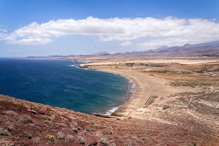 Unrecognizable people swimming, sunbathing and walking on La Tejita beach in Granadilla de Abona municipality, El Medano, Tenerife, Canary Islands, Spain, sunny summer dayの写真素材