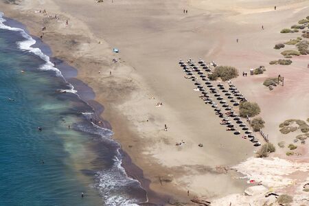 Unrecognizable people swimming, sunbathing and walking on La Tejita beach in Granadilla de Abona municipality, El Medano, Tenerife, Canary Islands, Spain, sunny summer dayの写真素材