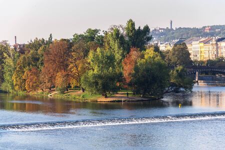 Strelecky Island with weir on Vltava river near National Theatre and the Charles Bridge, Prague, Czech Republic, sunny autumn dayの写真素材