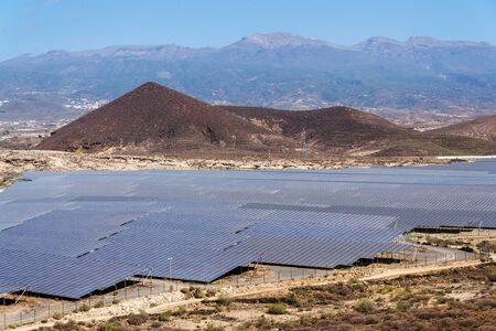 Solar panels at photovoltaics power station farm, future innovation energy concept, blue sky with Mount Teide in background, Tenerife, Canary Island, Spainの写真素材