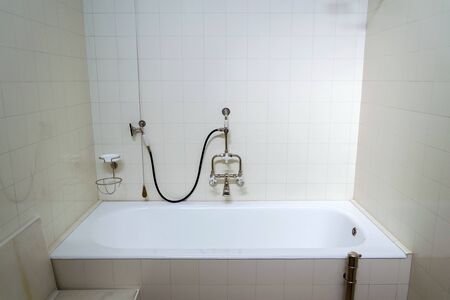 Beautiful shower bath with hot and cold water taps, white tile design wall, modern functionalism architectureの写真素材