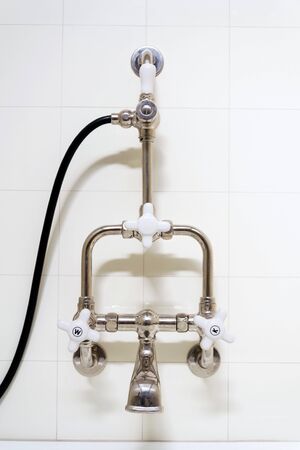 Beautiful shower bath with hot and cold water taps, white tile design wall, modern functionalism architectureの写真素材