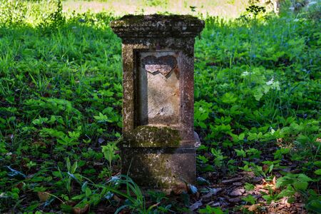 Broken heart on old tombstone, cemetery on a sunny day, love, marriage, death and life end conceptの写真素材