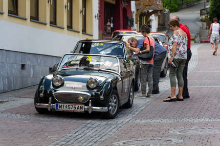 SAALBACH-HINTERGLEMM, AUSTRIA - JUNE 21 2018: People looking at vintage veteran car on June 21, 2018 in Saalbach-Hinterglemm, Austria.のeditorial素材