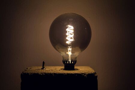 Large light bulb shining on homemade concrete lampの写真素材