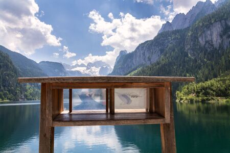 Information board on bank of the Vorderer Gosausee lake near Gosau showing melting glacier retreat history, Austria, sunny summer day, climate change and global warming conceptの写真素材