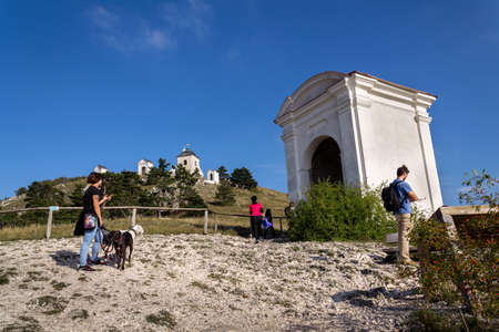 MIKULOV, CZECH REPUBLIC - OCTOBER 13 2019: People walk on the Way of the Cross on Holy Hill nature reserve with Pilgrimage Chapel of Saint Sebastian, bell tower and Holy Sepulchre on the summit on October 13, 2019 in Mikulov, Czech Republic.のeditorial素材
