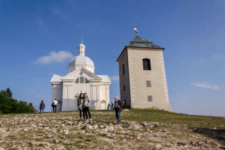 MIKULOV, CZECH REPUBLIC - OCTOBER 13 2019: People walk on the Way of the Cross on Holy Hill nature reserve with Pilgrimage Chapel of Saint Sebastian, bell tower and Holy Sepulchre on the summit on October 13, 2019 in Mikulov, Czech Republic.のeditorial素材